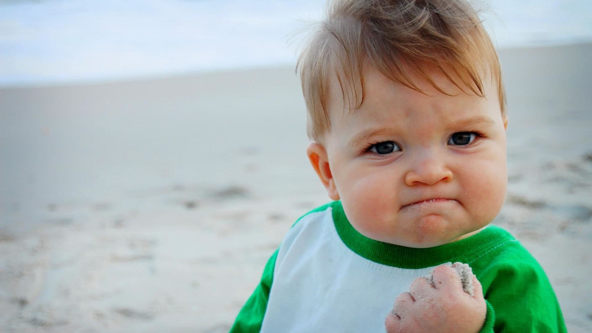 Success Kid clenching his fist on a beach