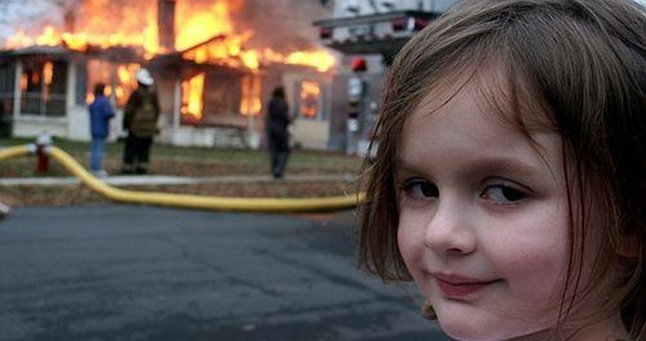 Zoe Roth smiling in front of a burning house in the Disaster Girl photograph